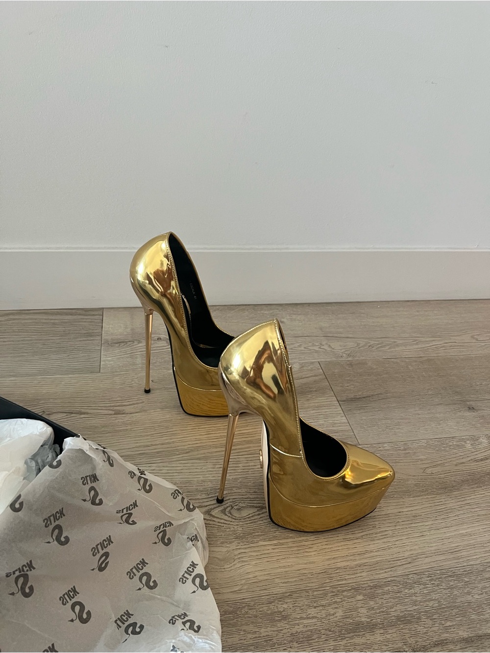 Slick Escala gold pumps with extremely high gold stiletto 7”